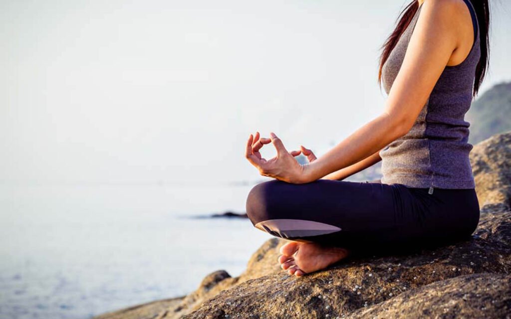 Woman meditating on a beach