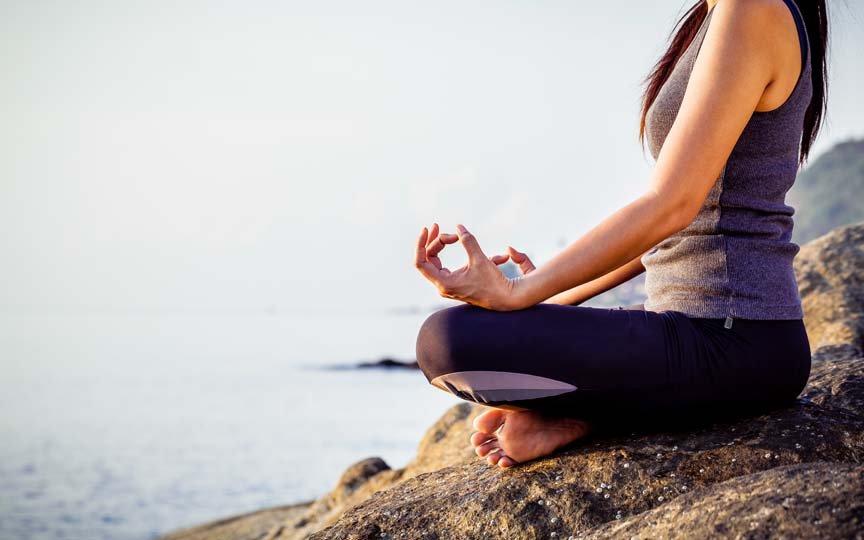 Woman meditating on a beach